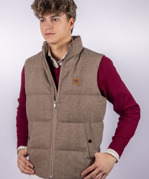 Chaleco guateado color espiga MP, con cuello alto, cierre de cremallera en el delantero y parche con el logo de la marca, diseño cálido y elegante, ideal para actividades al aire libre o looks casuales sofisticados.